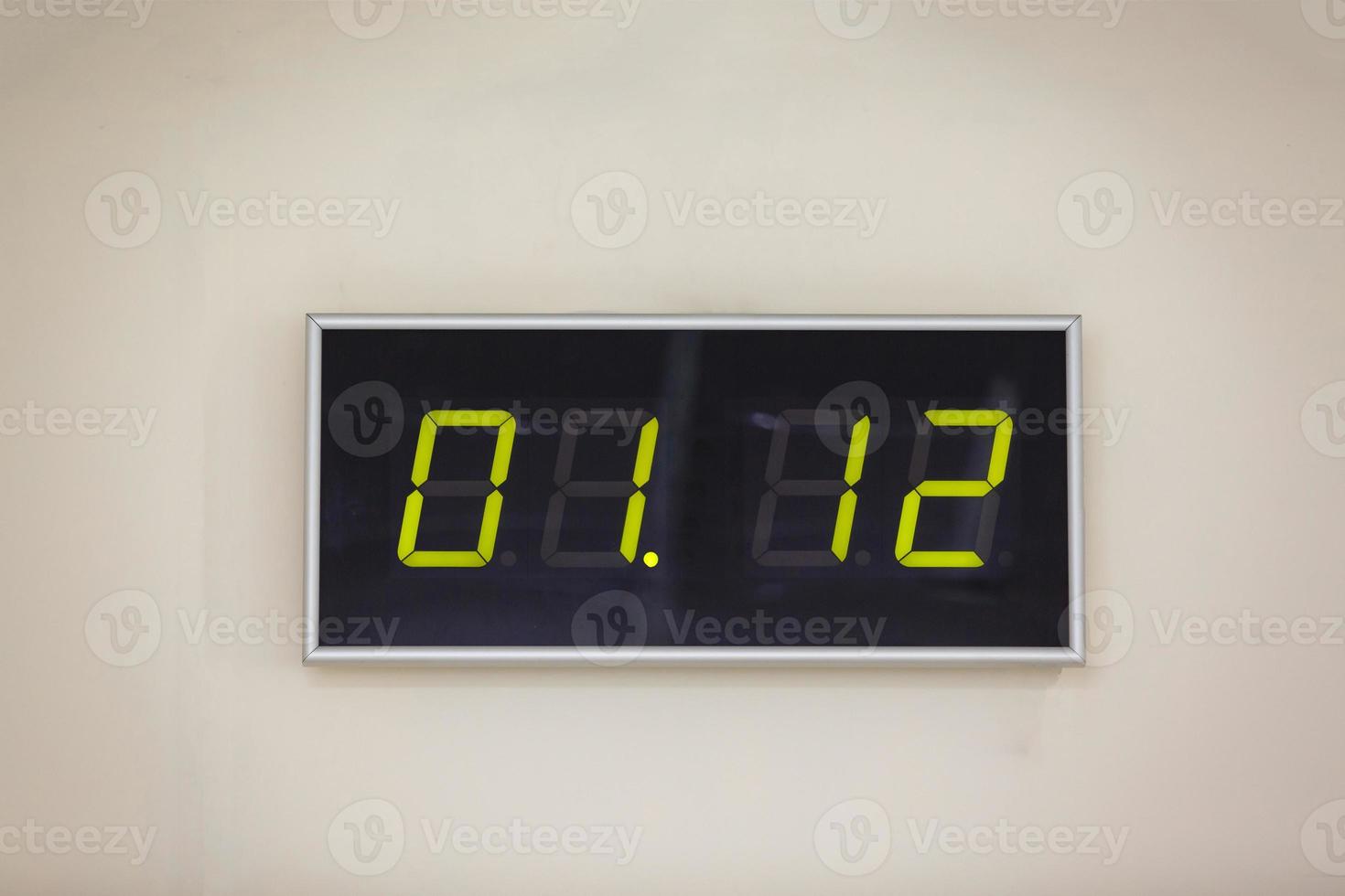 Black digital clock on a white background showing time 01.12 photo
