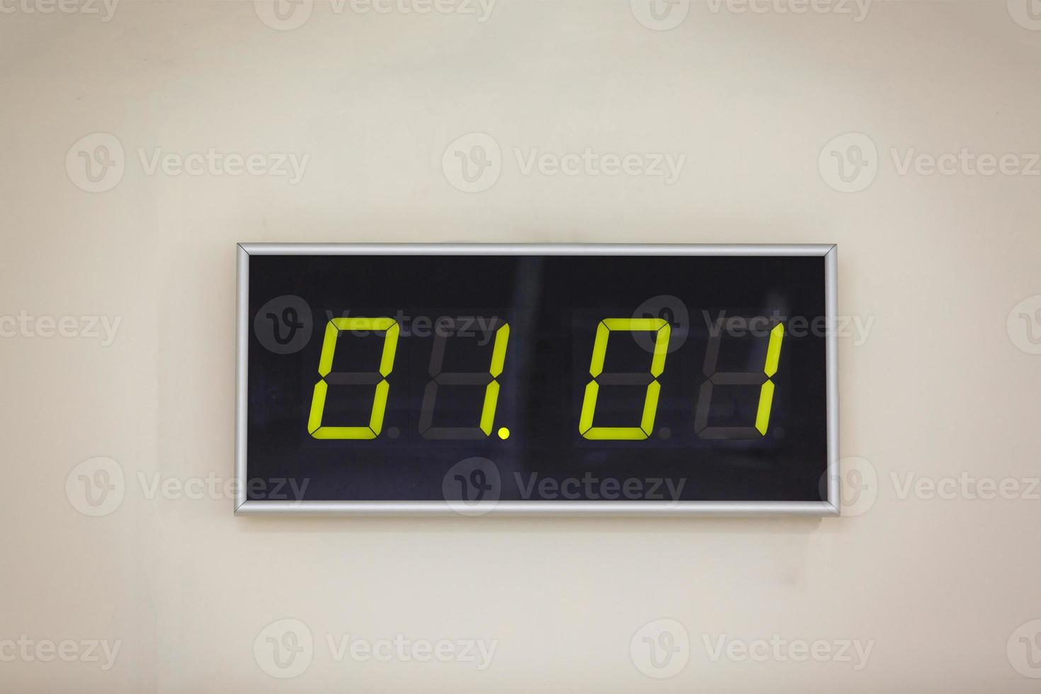 reloj digital negro sobre un fondo blanco que muestra la hora 01.01 enero día del mes calendario invierno año nuevo concepto vacío foto