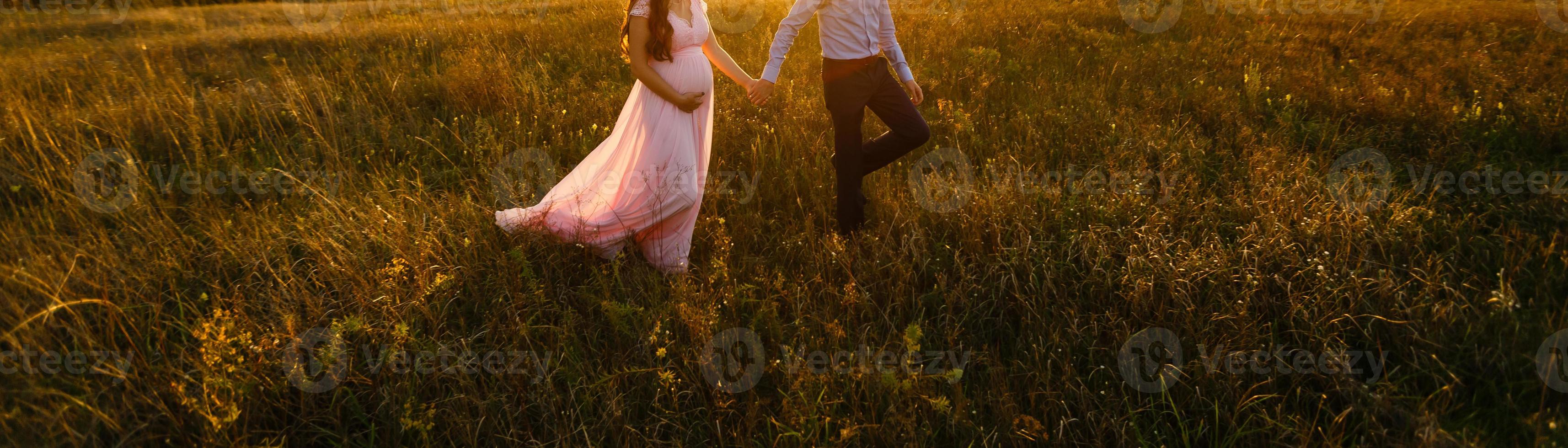 hermosa chica embarazada y su marido en la naturaleza foto