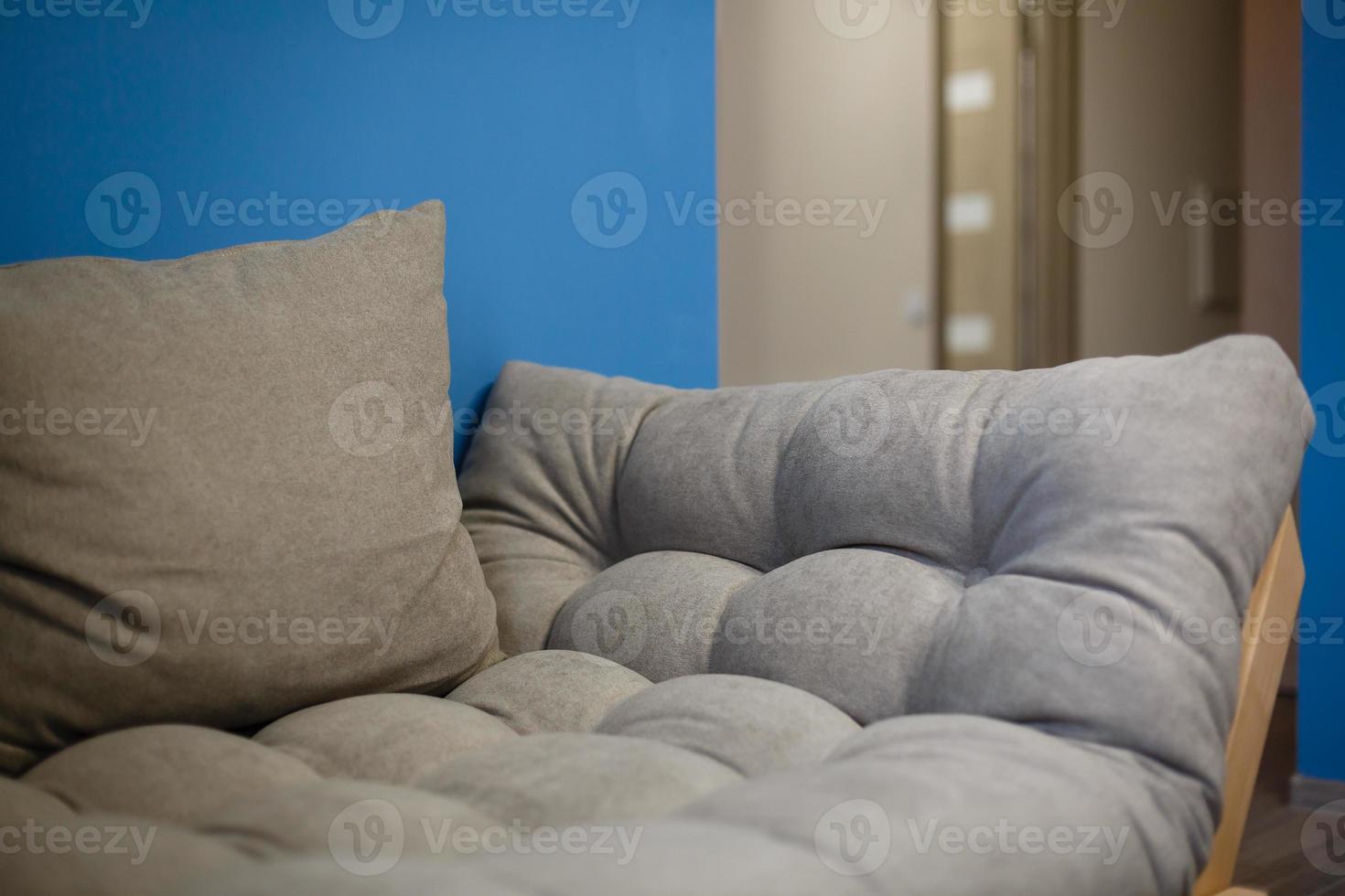 Modern white design sofa against blue wall photo