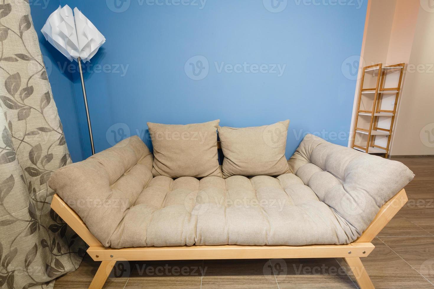 Modern white design sofa against blue wall photo