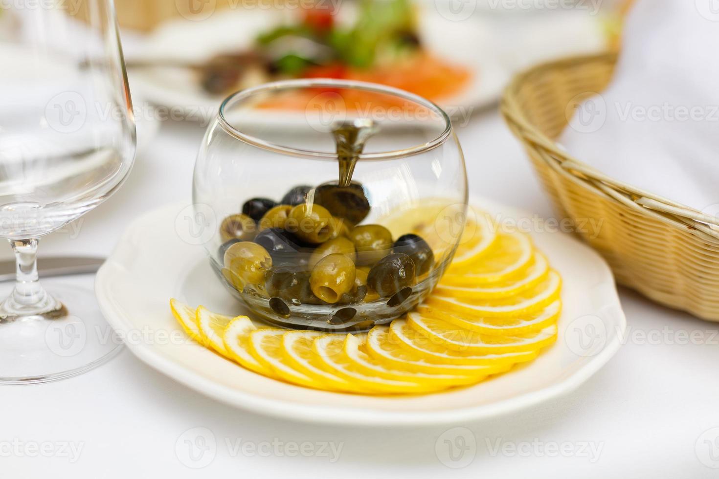 Delicious bruschetta with tomatoes on plate on table close-up Buffet table white plates olives photo