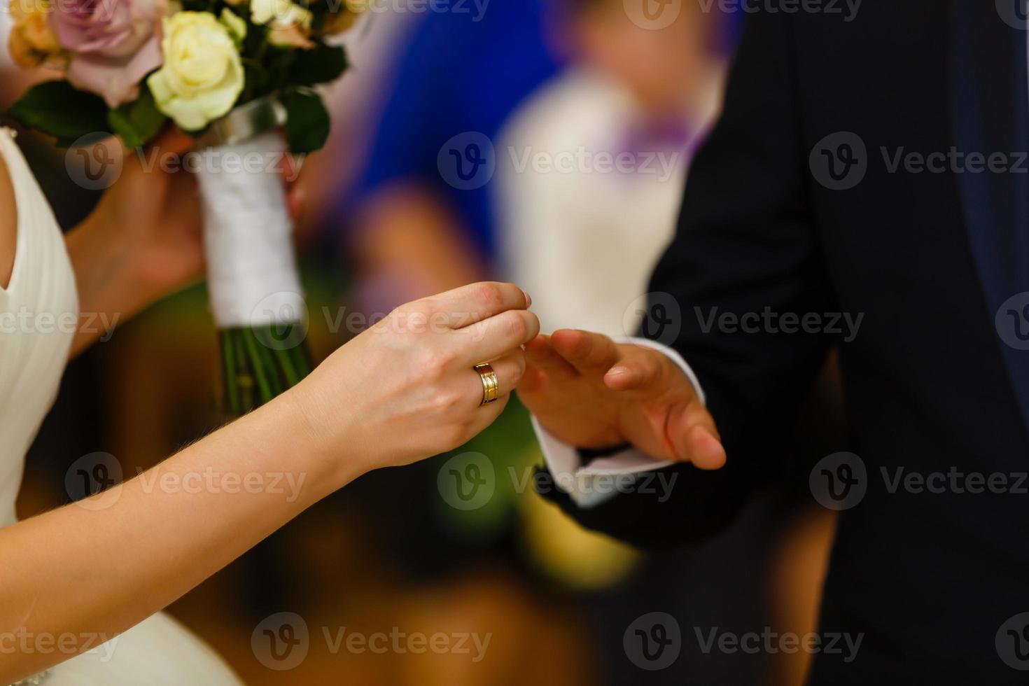 Wedding day. The groom places the ring on the bride's hand. Photo closeup