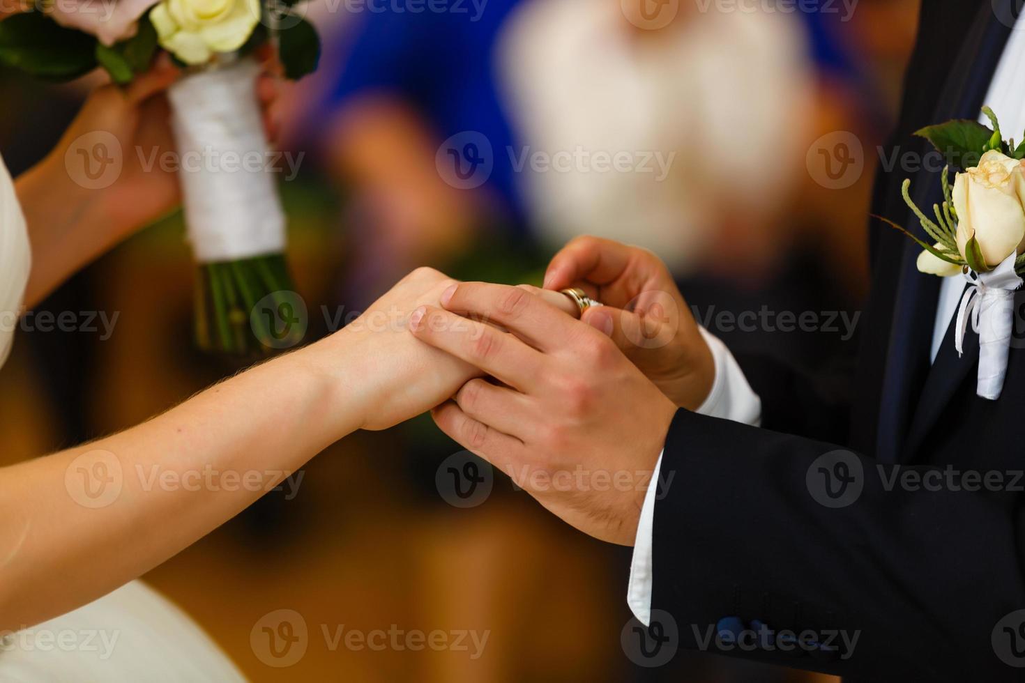 Newlyweds exchange rings, groom puts the ring on the bride's hand in marriage registry office photo