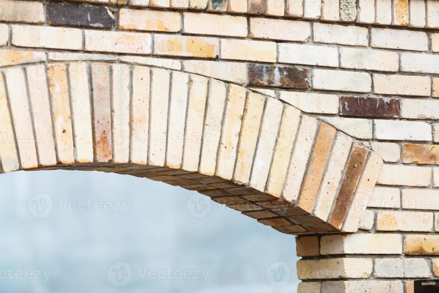 Bright blue Morning Glory flower and green leaves against stone block wall with edge of brick arch Brick arch edge photo