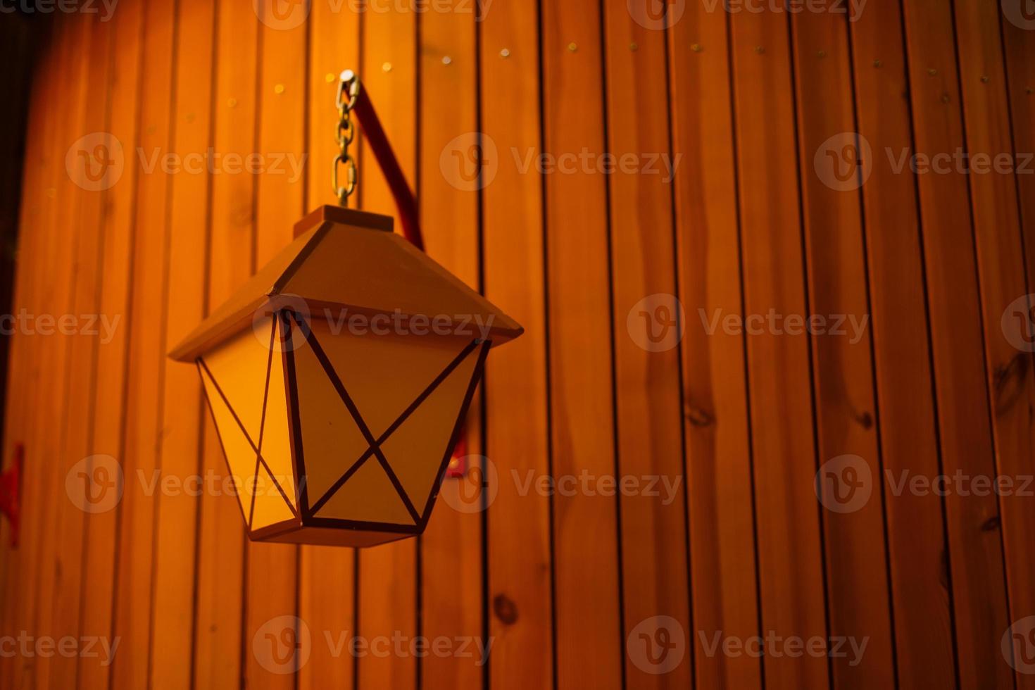 Lantern on a wooden house wall photo