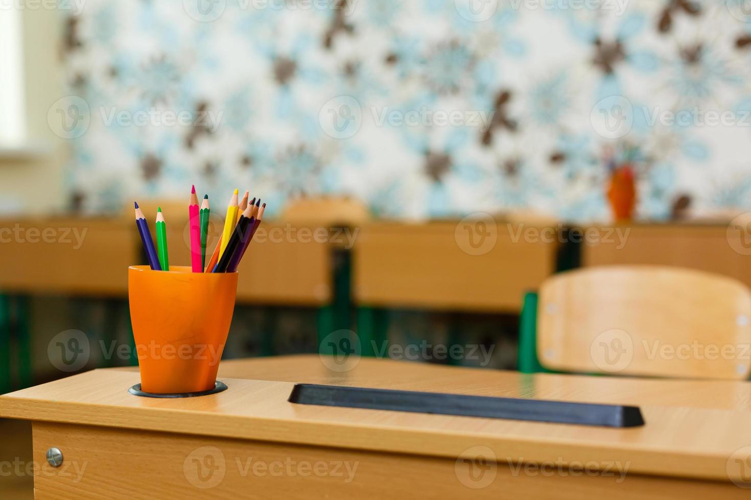 color pencils in glass on desk with shallow depth of field photo