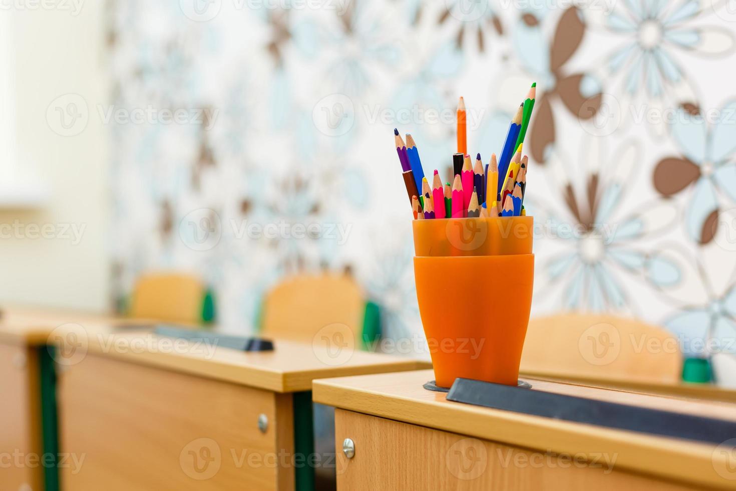 color pencils in glass on desk with shallow depth of field photo