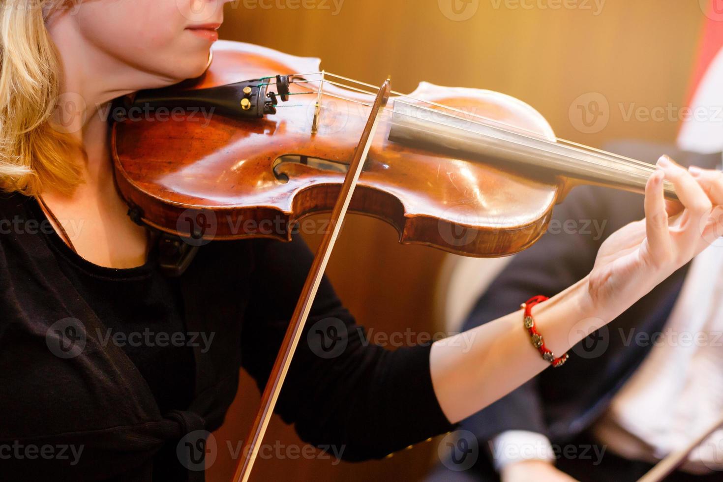 The hand of the girl playing the violin in dark colors photo