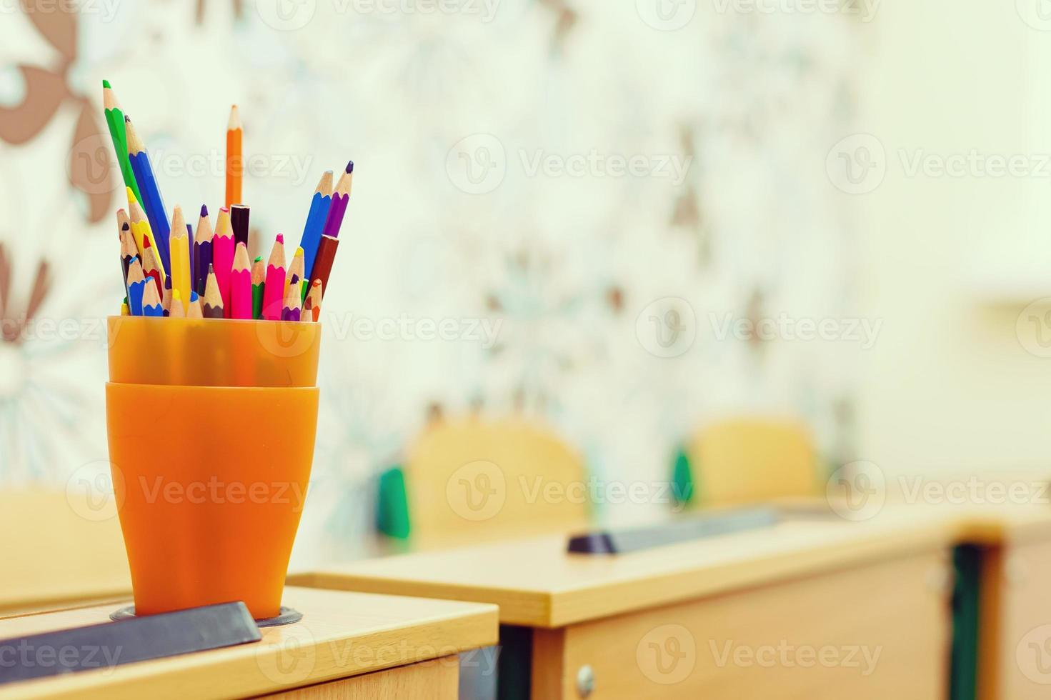 color pencils in glass on desk with shallow depth of field photo