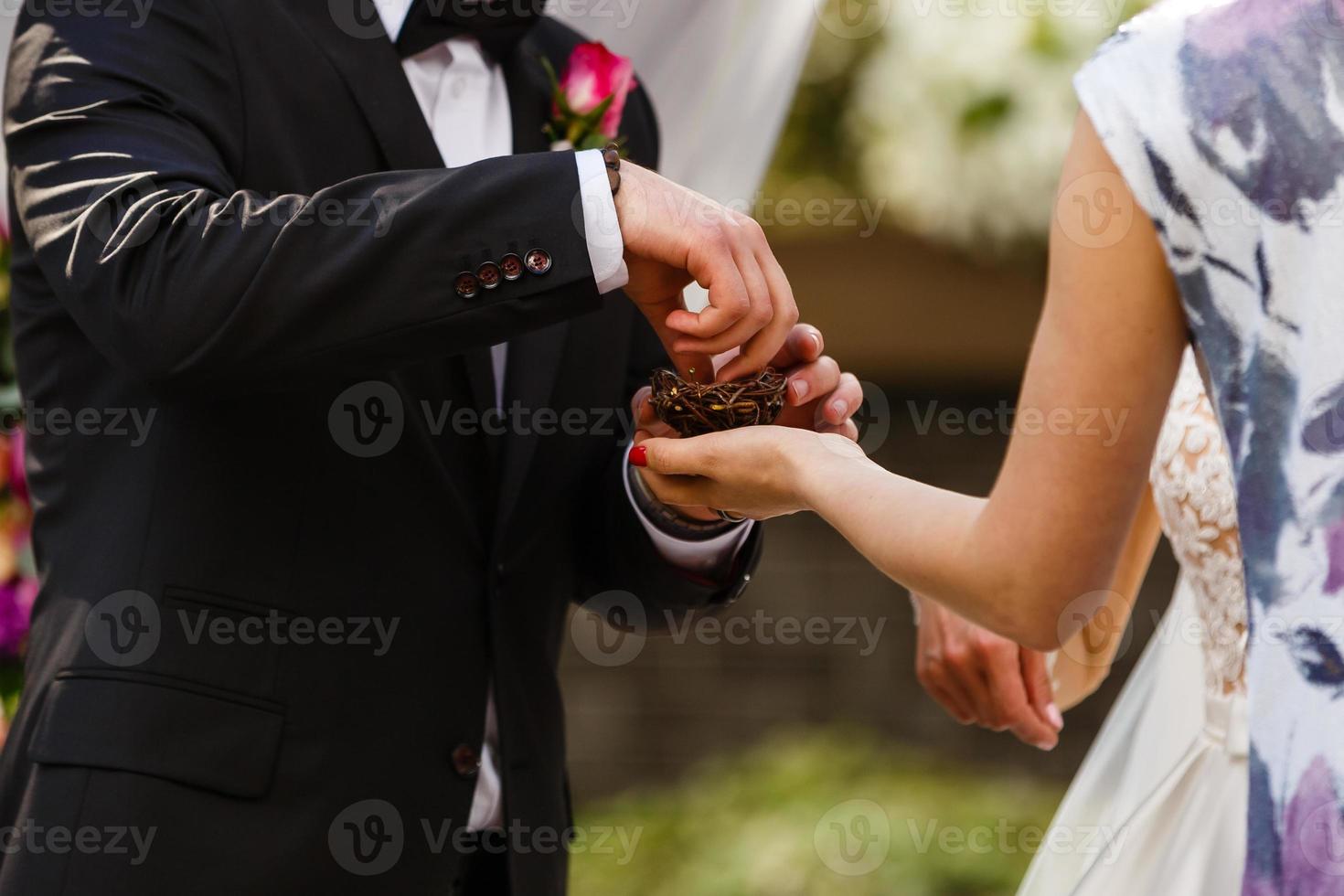 The bride and groom exchange rings during a wedding ceremony, a wedding in the summer garden photo