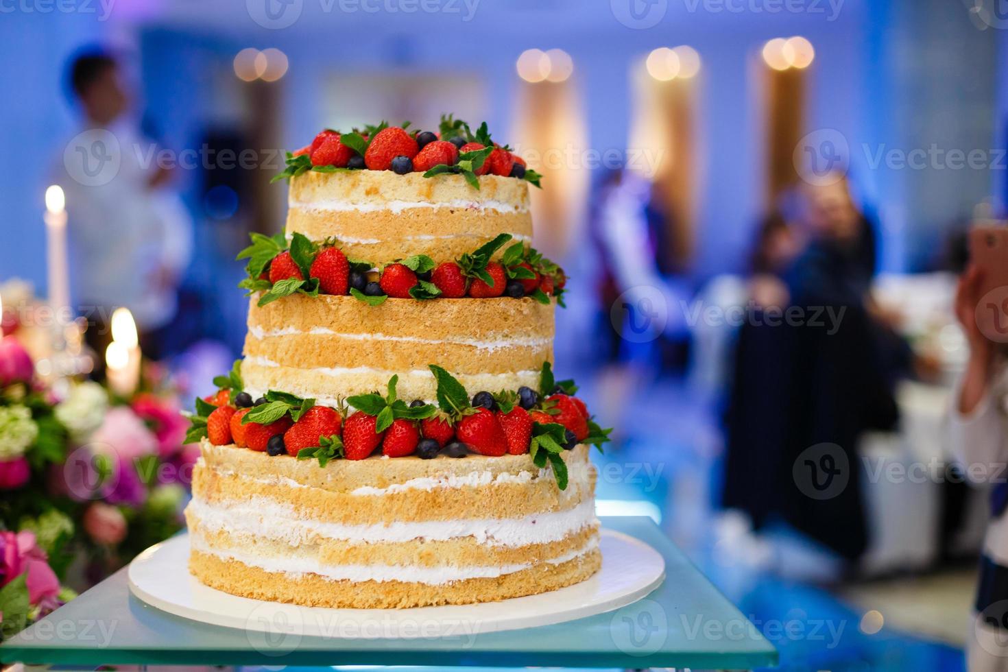 wedding cake with open biscuit shortcakes, cream and fruit. blueberries, strawberries, raspberries, red currants. photo