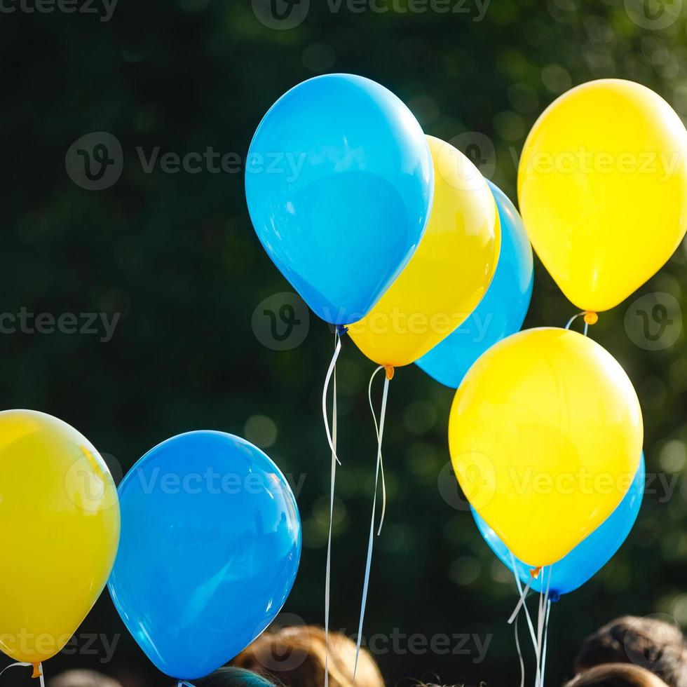 blue and yellow balloons in the city festival on blue sky background photo