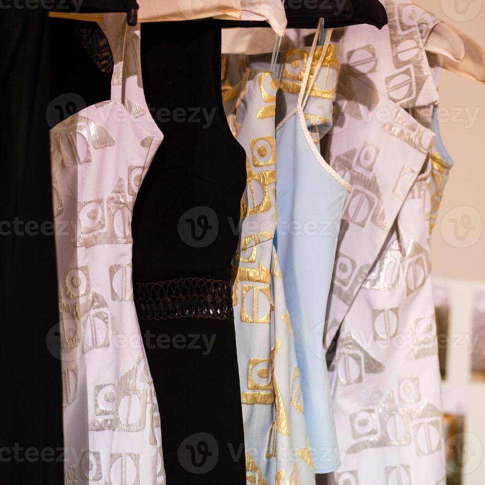 Pastel colorful dresses hang on the pegs photo