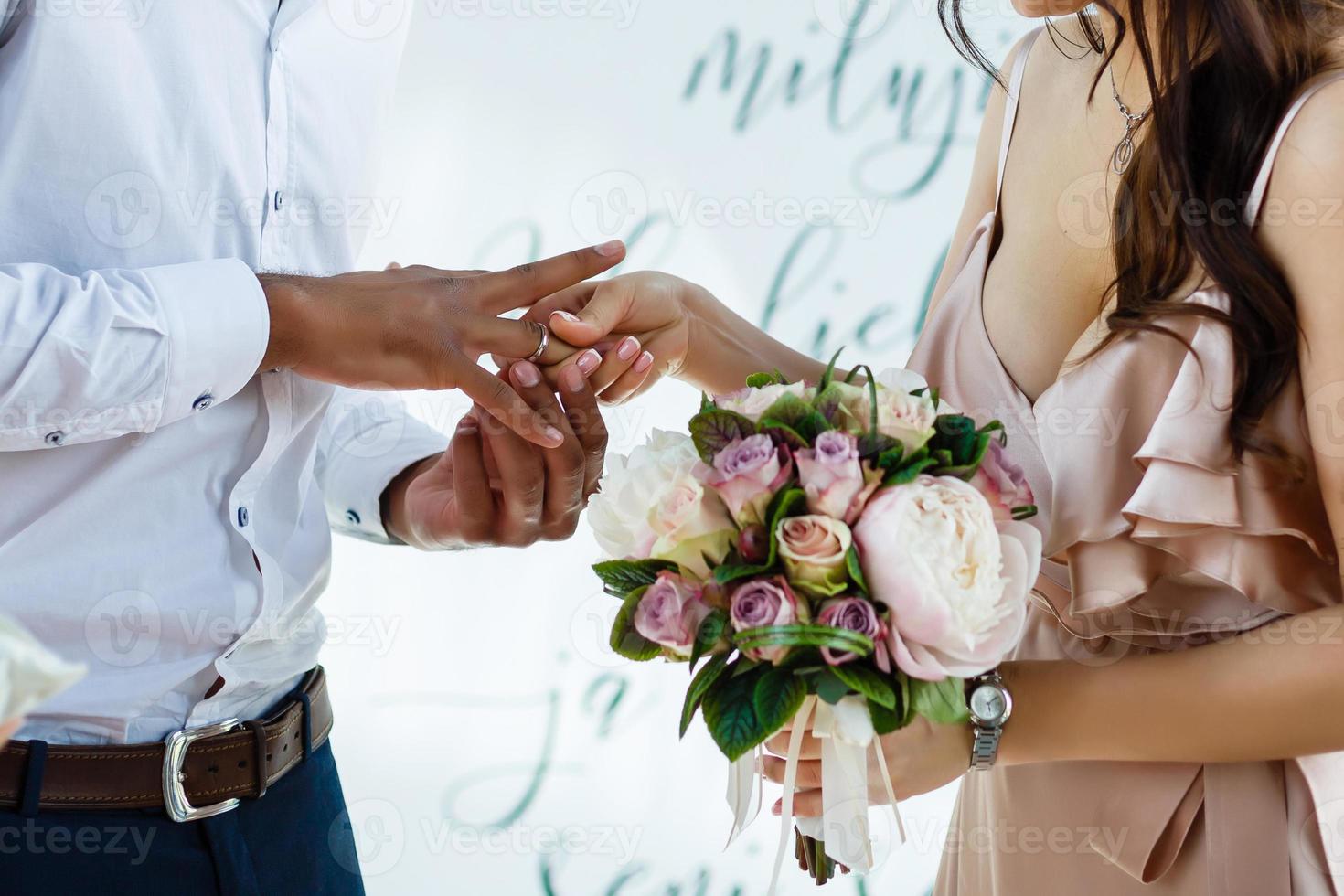 The bride and groom exchange rings during a wedding ceremony, a wedding in the summer garden photo