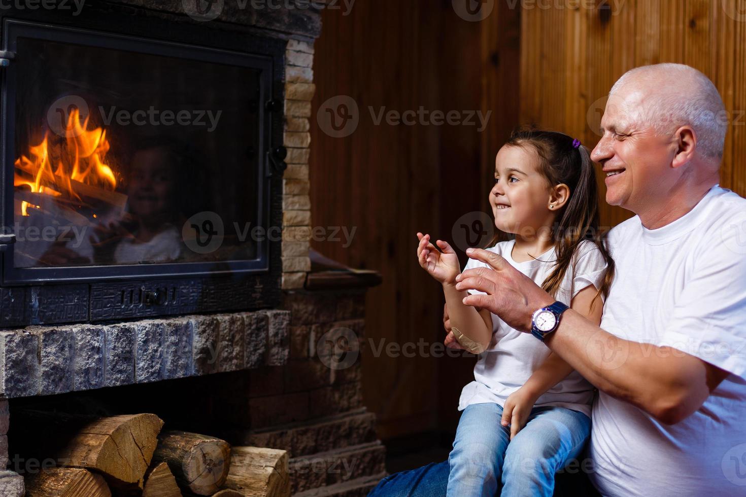 Grandfather and granddaughter playing Grandfather and little girl fireplace photo