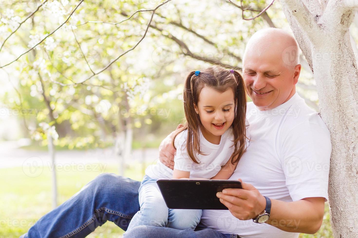 grandfather and his little granddaughter together in garden photo