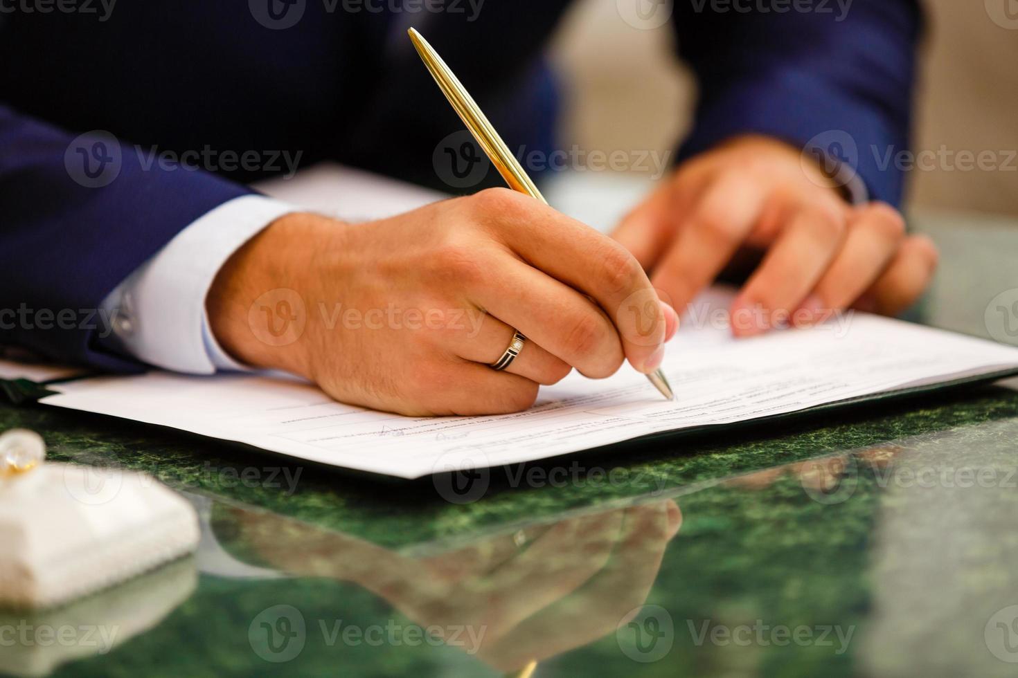 Closeup of a businessman's hands while writing some documents photo
