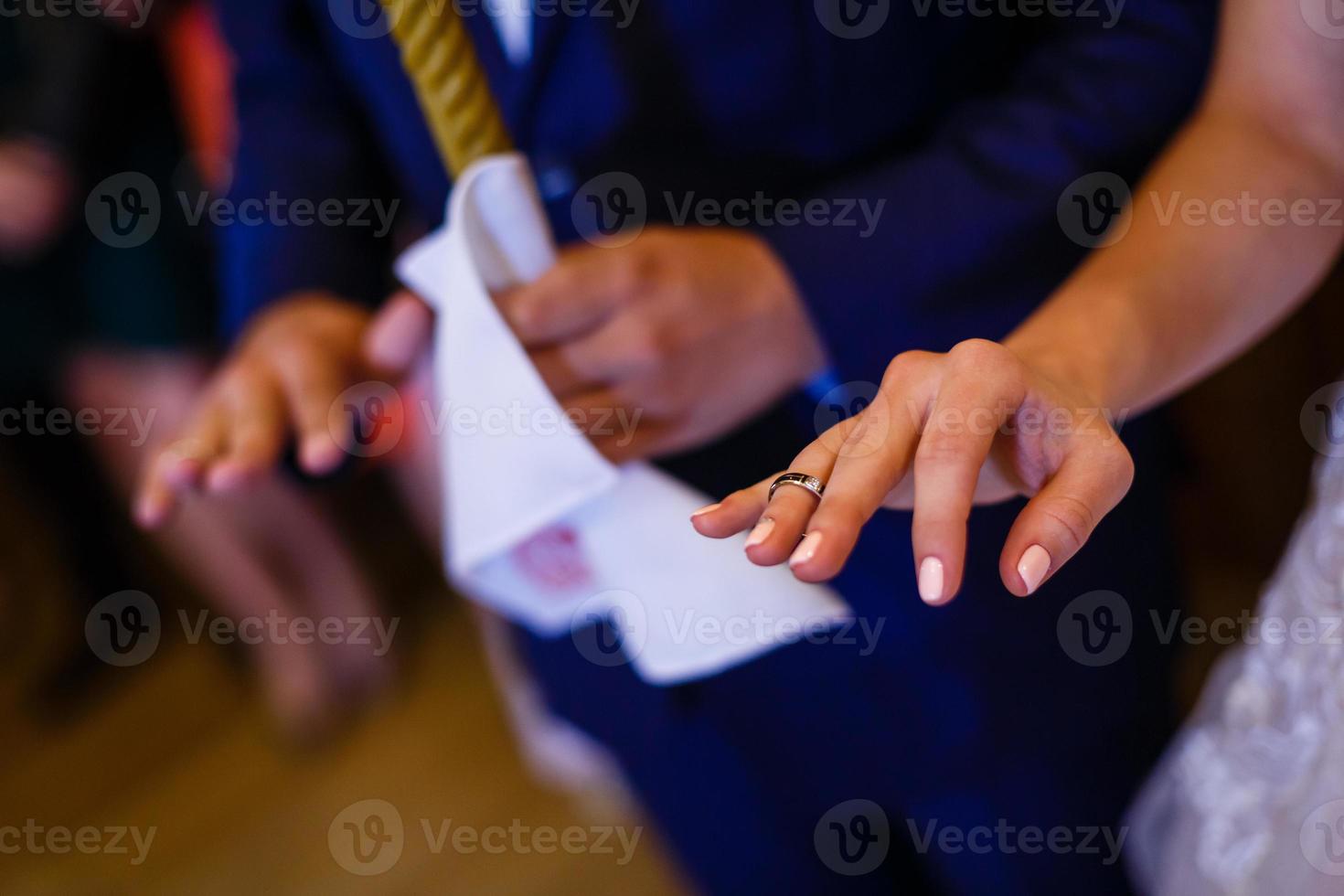 novio deslizando el anillo en el dedo de la novia en la boda foto