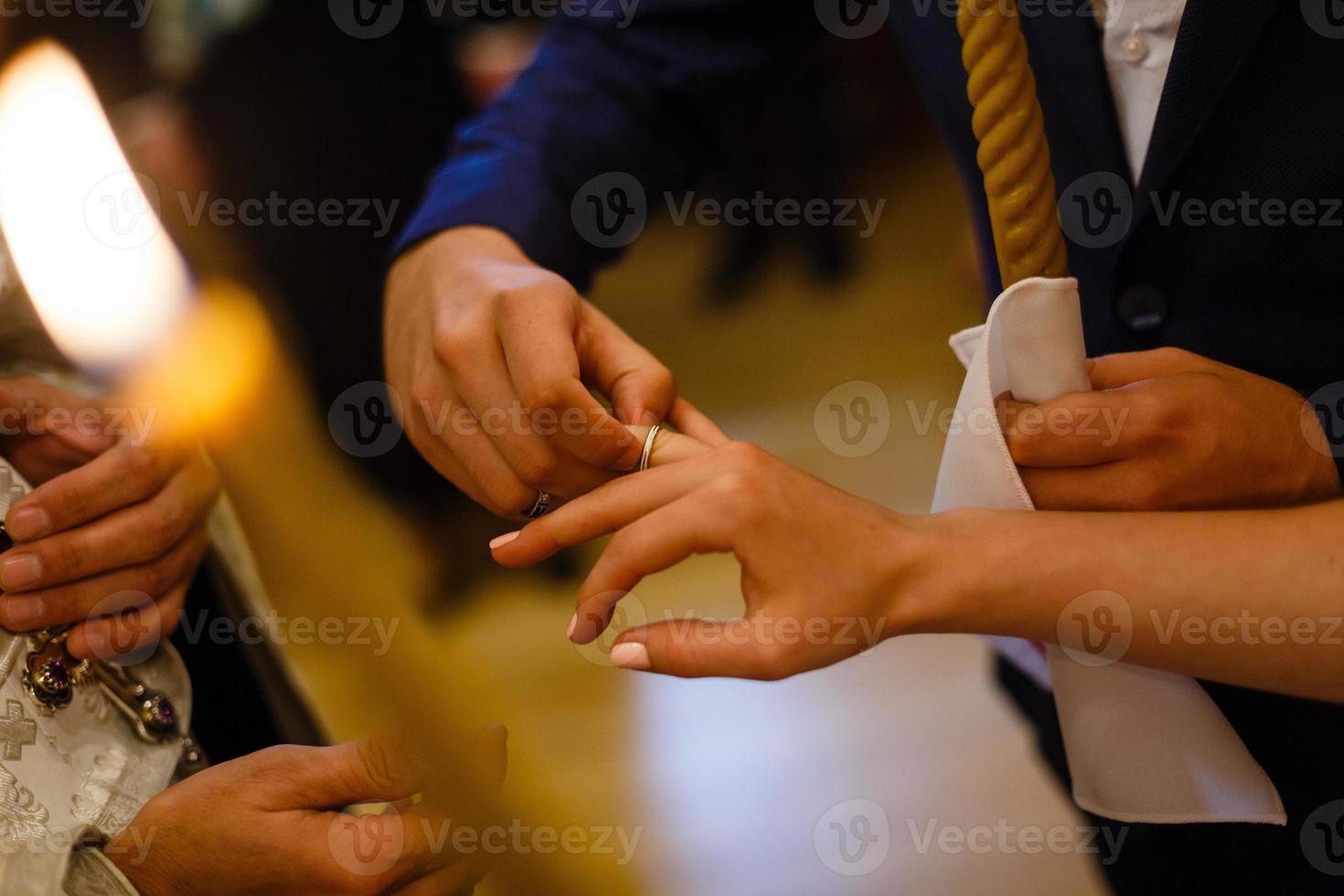 novio deslizando el anillo en el dedo de la novia en la boda foto