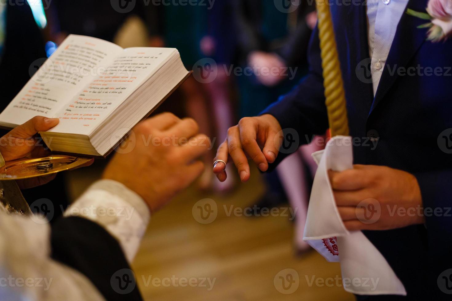 novio deslizando el anillo en el dedo de la novia en la boda foto