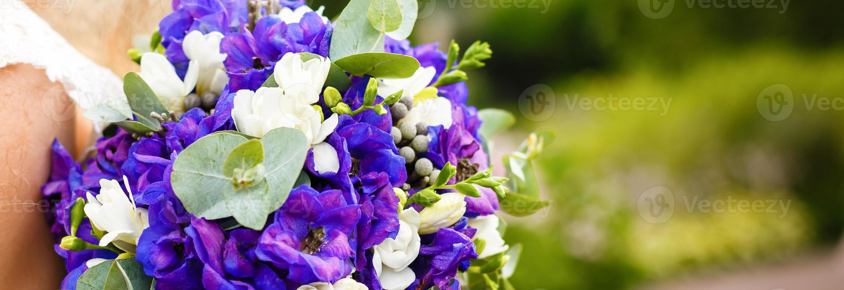 bridal bouquet blue with white flowers in the bride's hands. photo