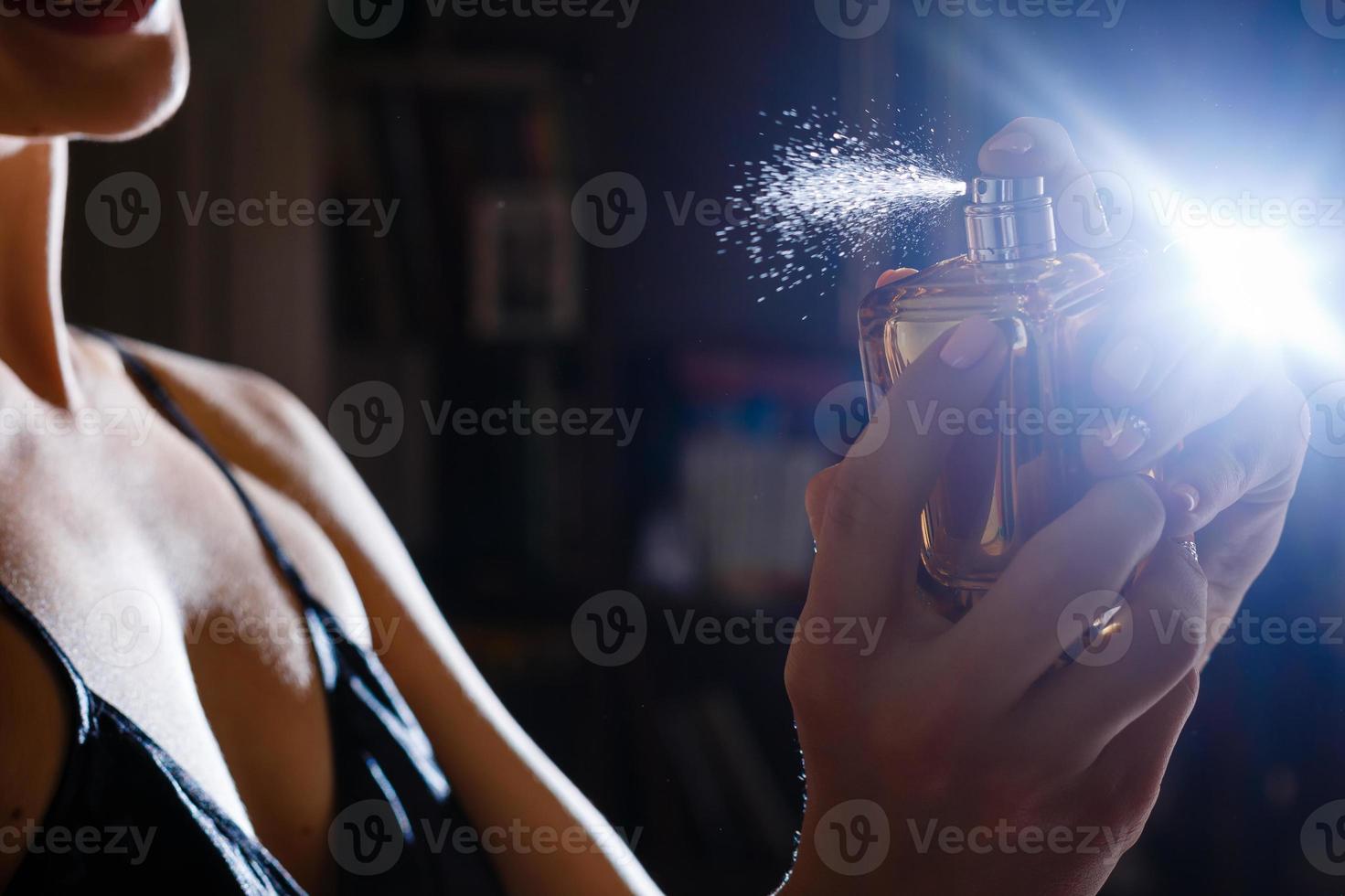 close up of spray on woman body isolated black photo