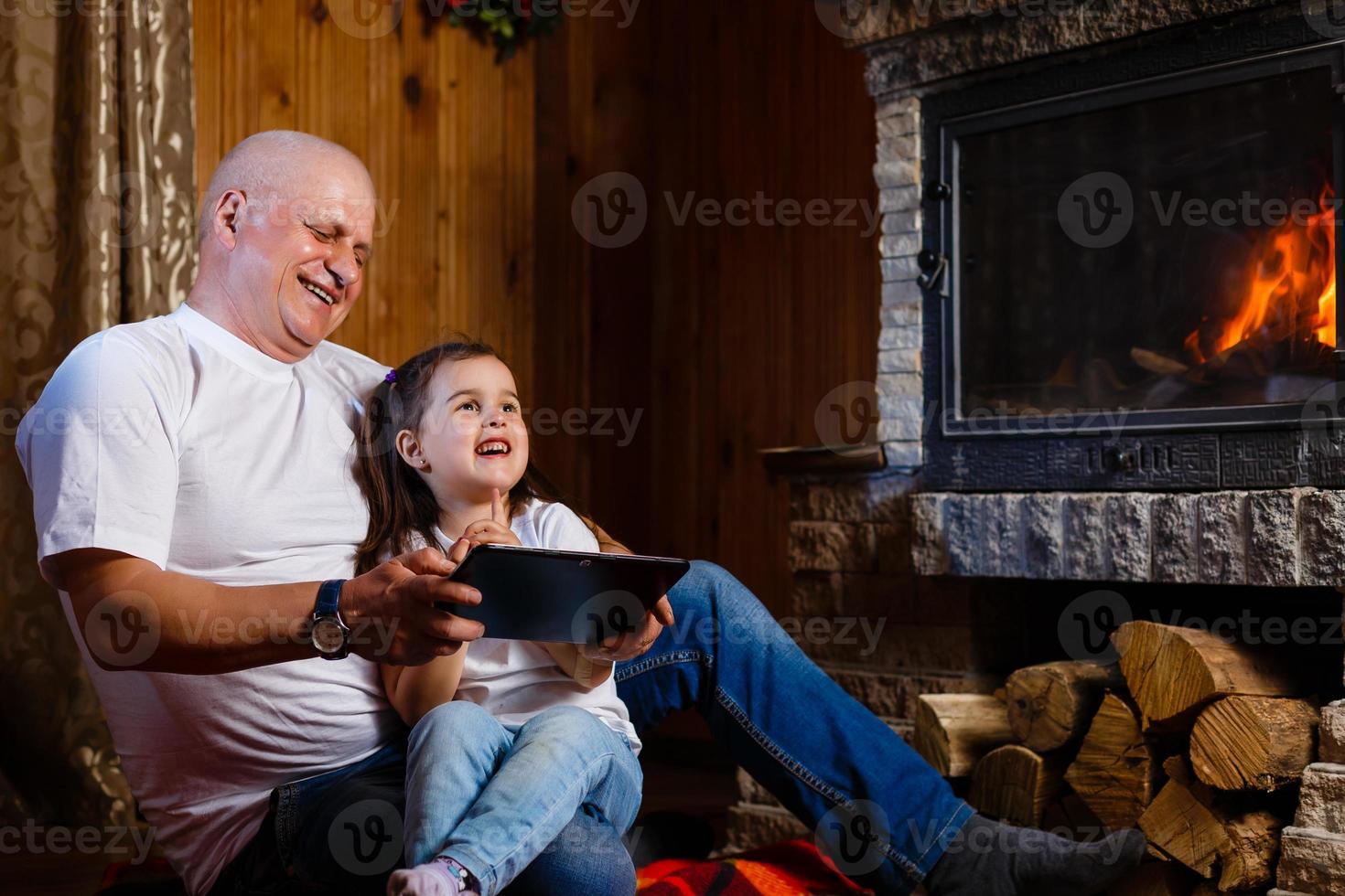 Grandfather and granddaughter playing Grandfather and little girl fireplace Tablet, gadget, play, touch, photo