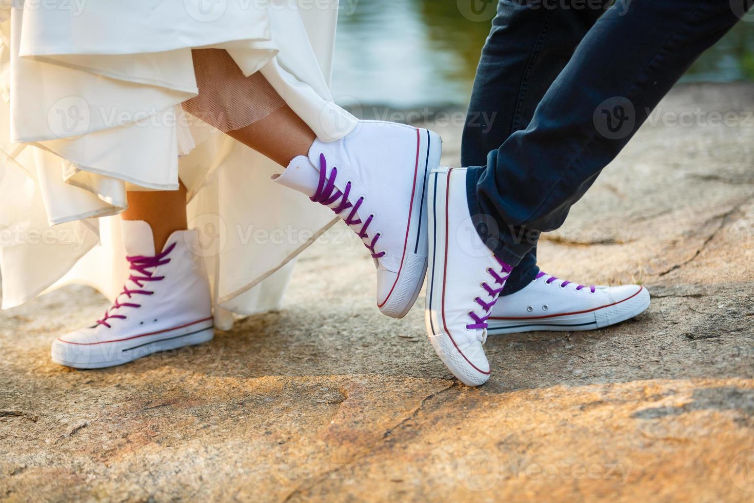 historia de amor contada por botas. pies humanos de cerca. hombre y mujer en zapatillas. chica con zapatos blancos. chico con zapatillas negras y denim. pareja hipster en verano. las piernas se cierran. foto