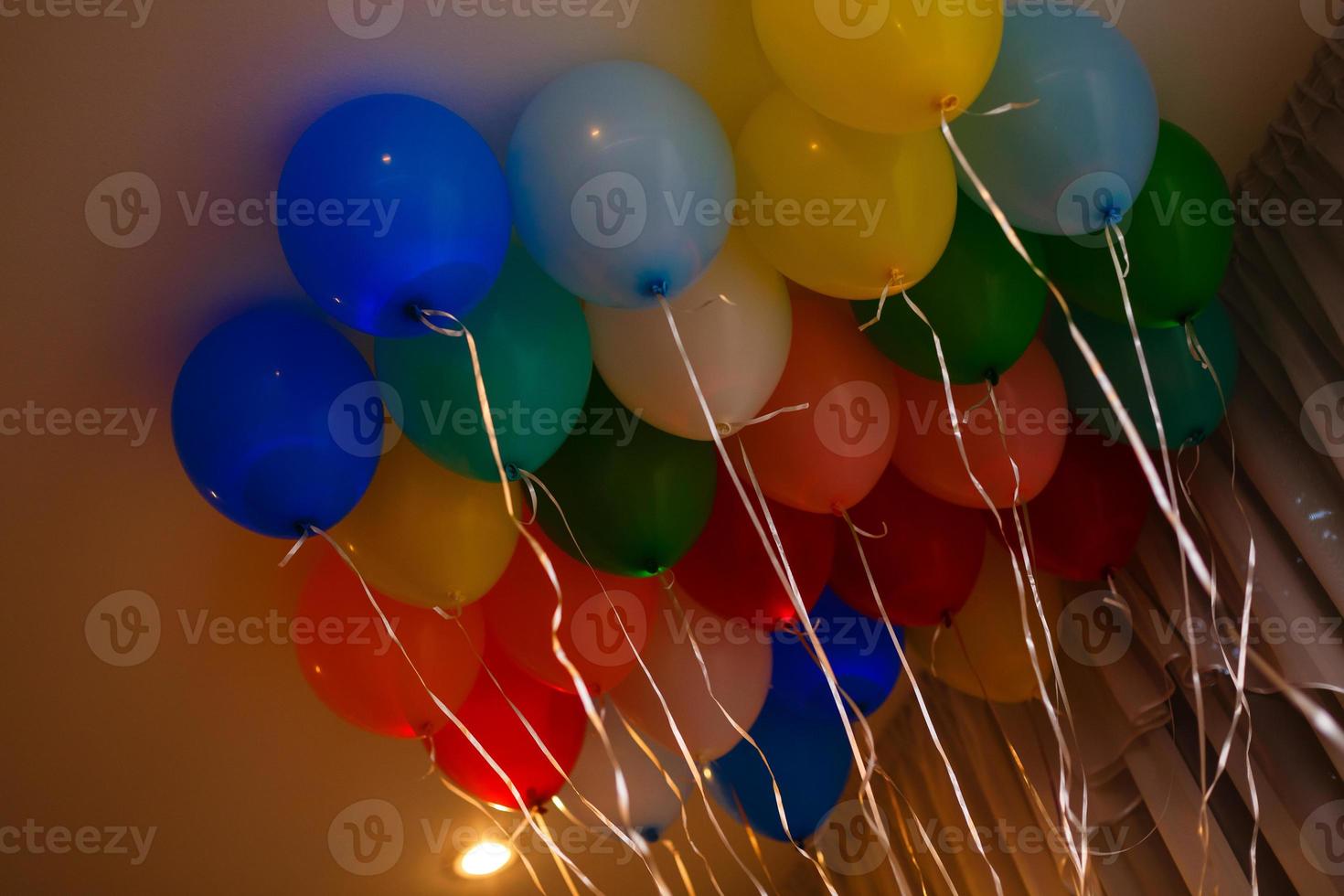 Color balls, colored polymer gel, hydrogel beads against the background of the wall and the falling rays of the sun emanating from the window. Concept holiday, birthday, congratulations photo