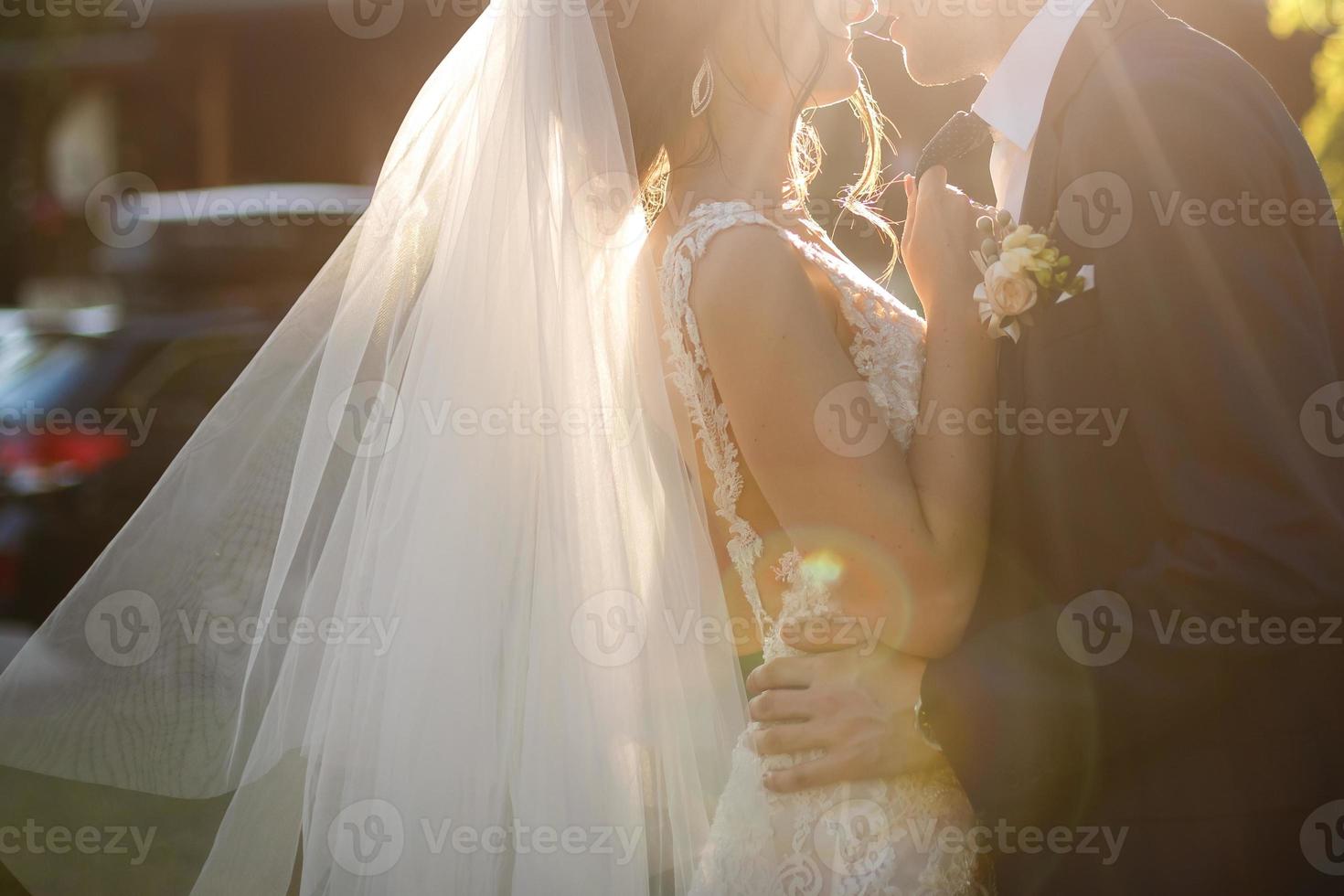 novia y novio en el día de la boda caminando al aire libre en la naturaleza primaveral. pareja nupcial, mujer recién casada feliz y hombre abrazándose en el parque verde. amorosa pareja de novios al aire libre. la novia y el novio foto