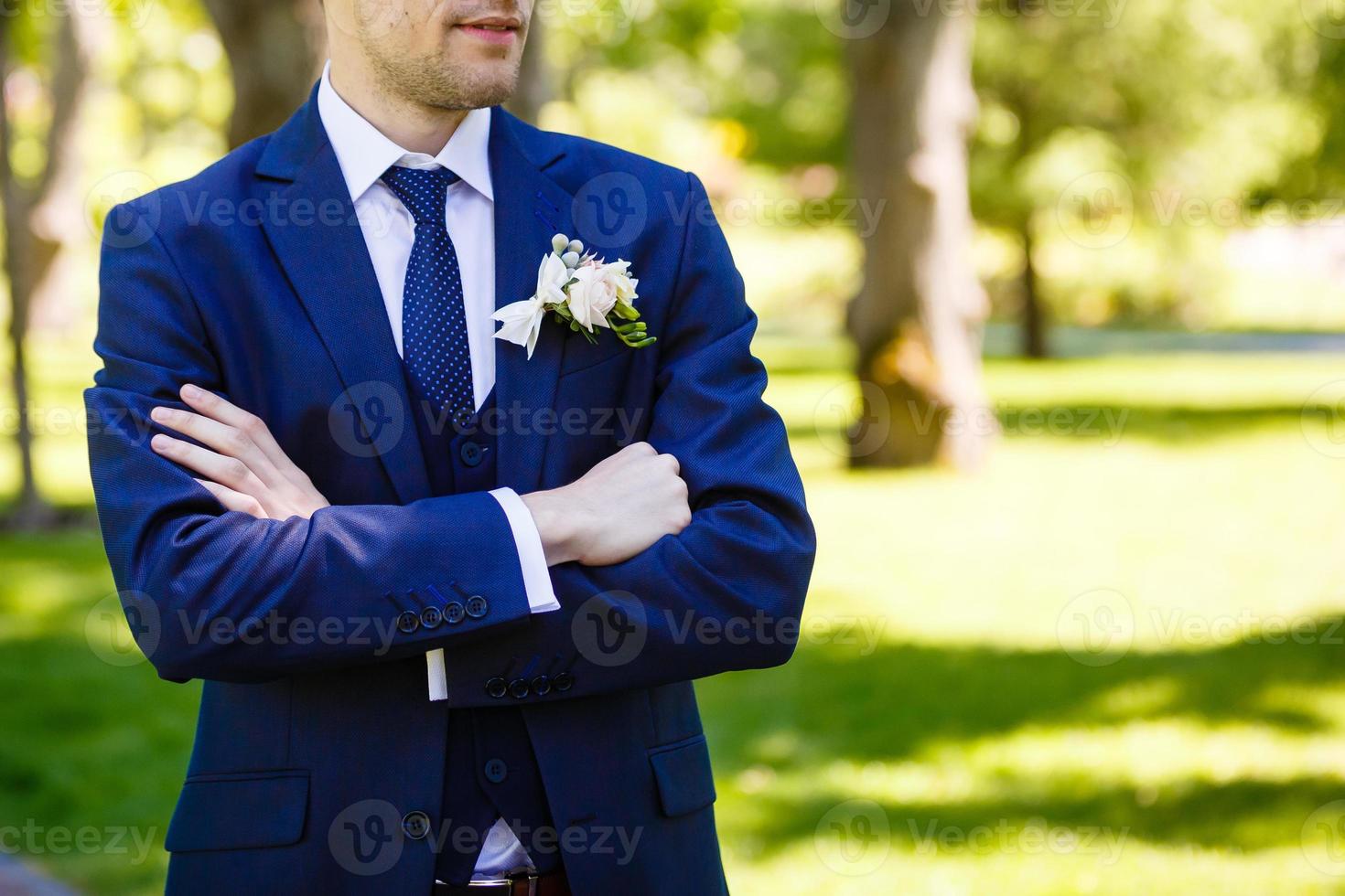 Midsection closeup of confident groom with arms crossed on his chest. photo