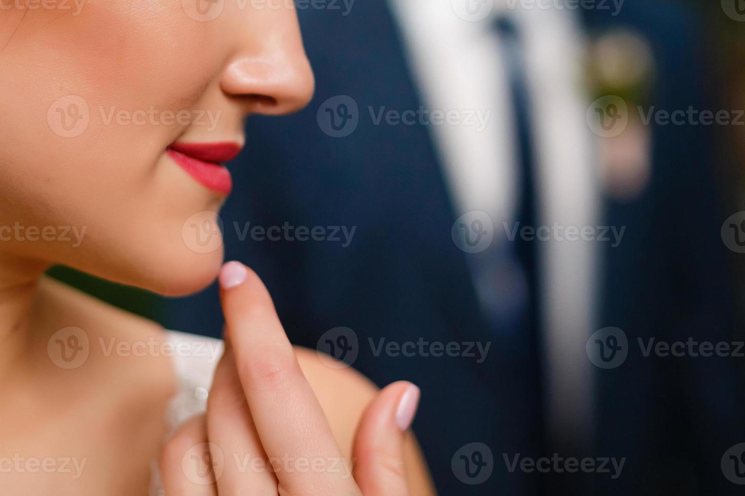 stylish wedding bride smiling. modern bride hugging groom, lips and earrings close up. fine art wedding photo, romantic moment, long edge photo