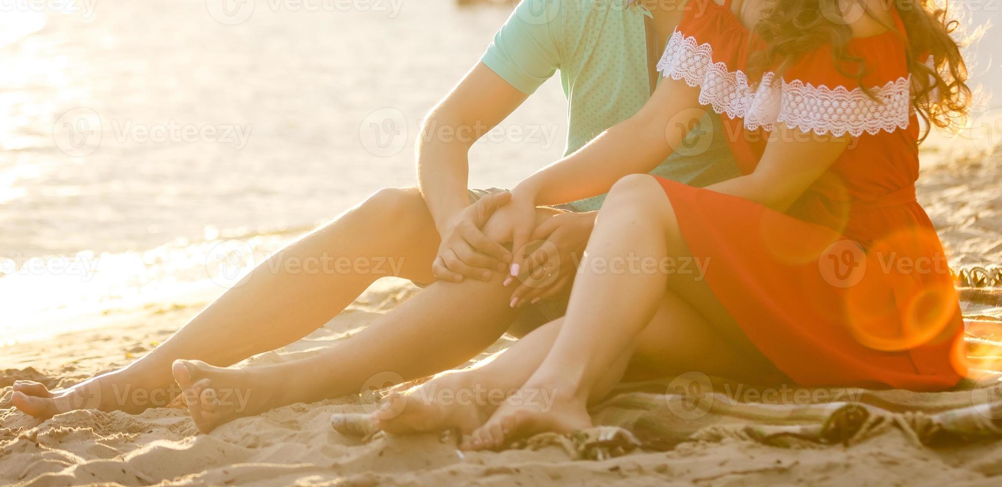 Young couple sitting on the beach. sunset photo