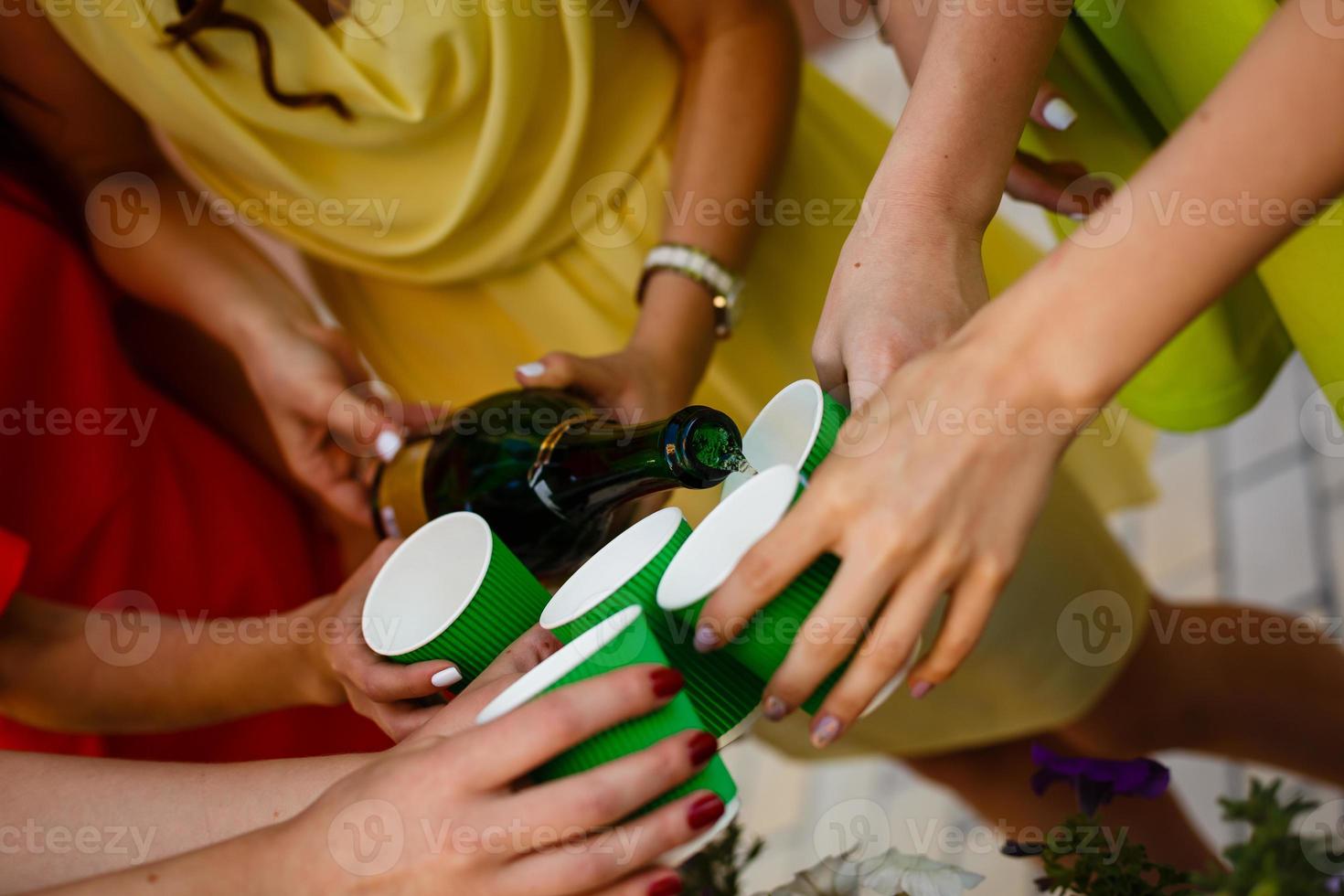 Pour champagne into disposable glasses photo