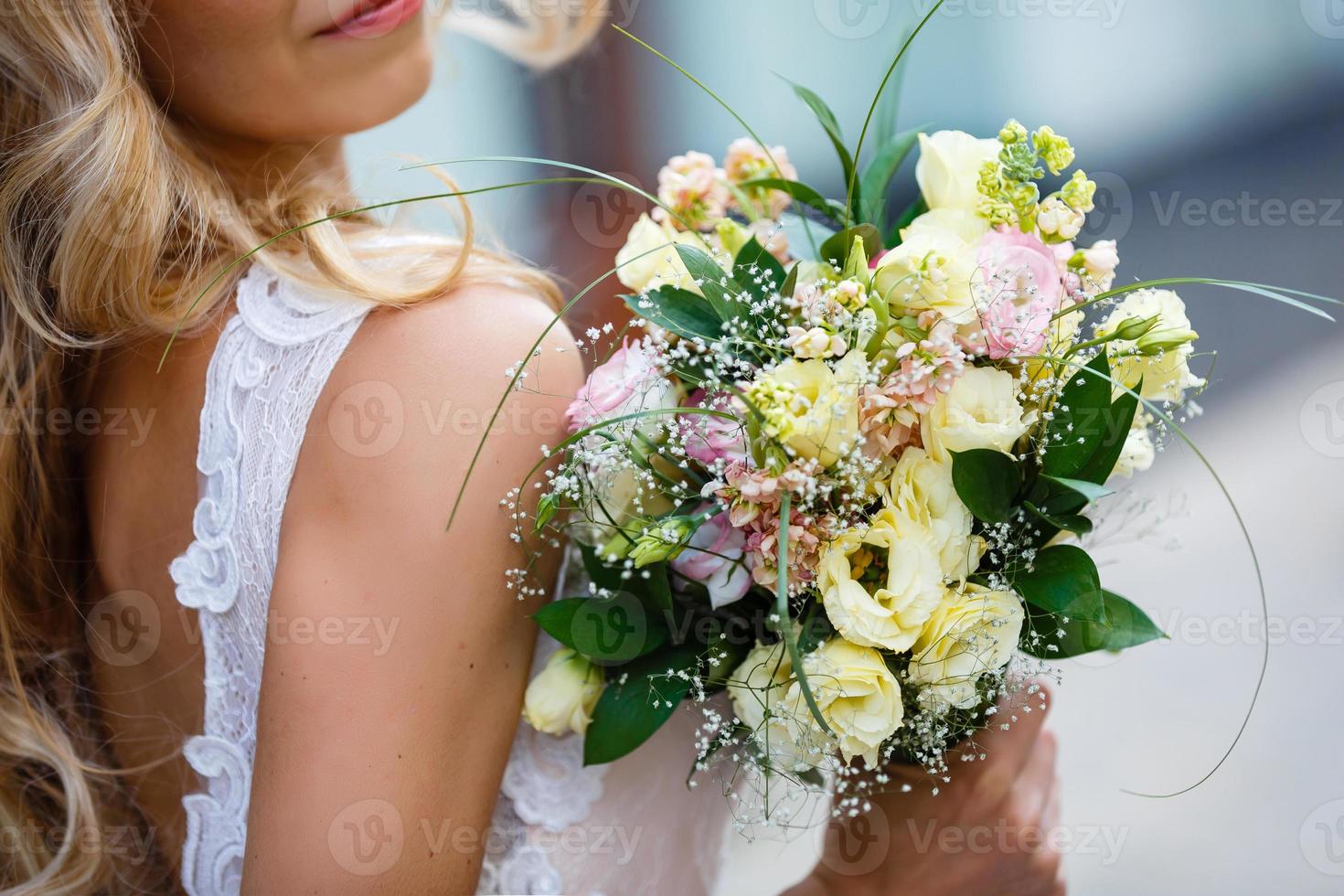 Bridal bouquet. The bride's . Beautiful of white flowers and greenery, decorated with silk ribbon, lies on vintage wooden chair photo