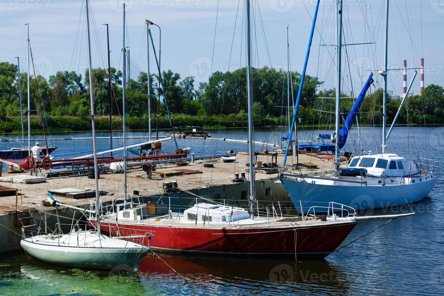 Boats anchored on the bank of the river, across the river residential houses, wide river, rest place photo