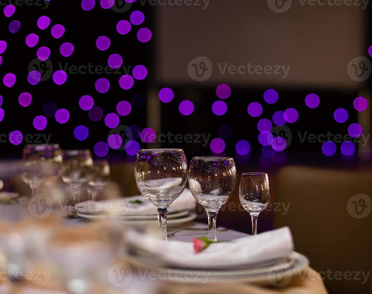 Beautiful table setting with crockery and flowers for a party, wedding reception or other festive event. Glassware and cutlery for catered event dinner. photo
