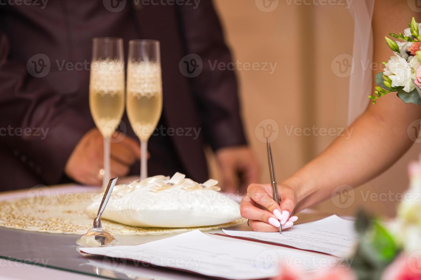 la novia escribe con un bolígrafo, un primer plano de la mano de una mujer escribiendo en papel foto