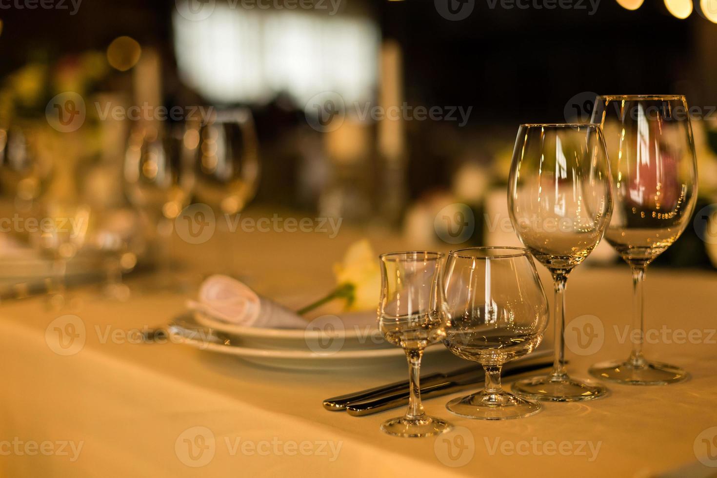 Beautiful table setting with crockery and flowers for a party, wedding reception or other festive event. Glassware and cutlery for catered event dinner. photo