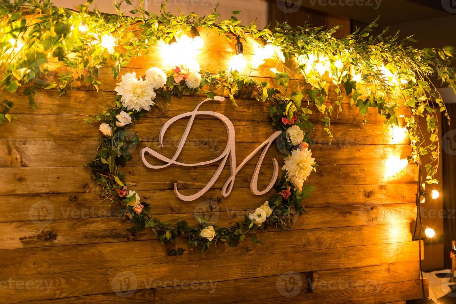 Wooden natural garland decorated with bulb lights on wedding ceremony. Dim light photo
