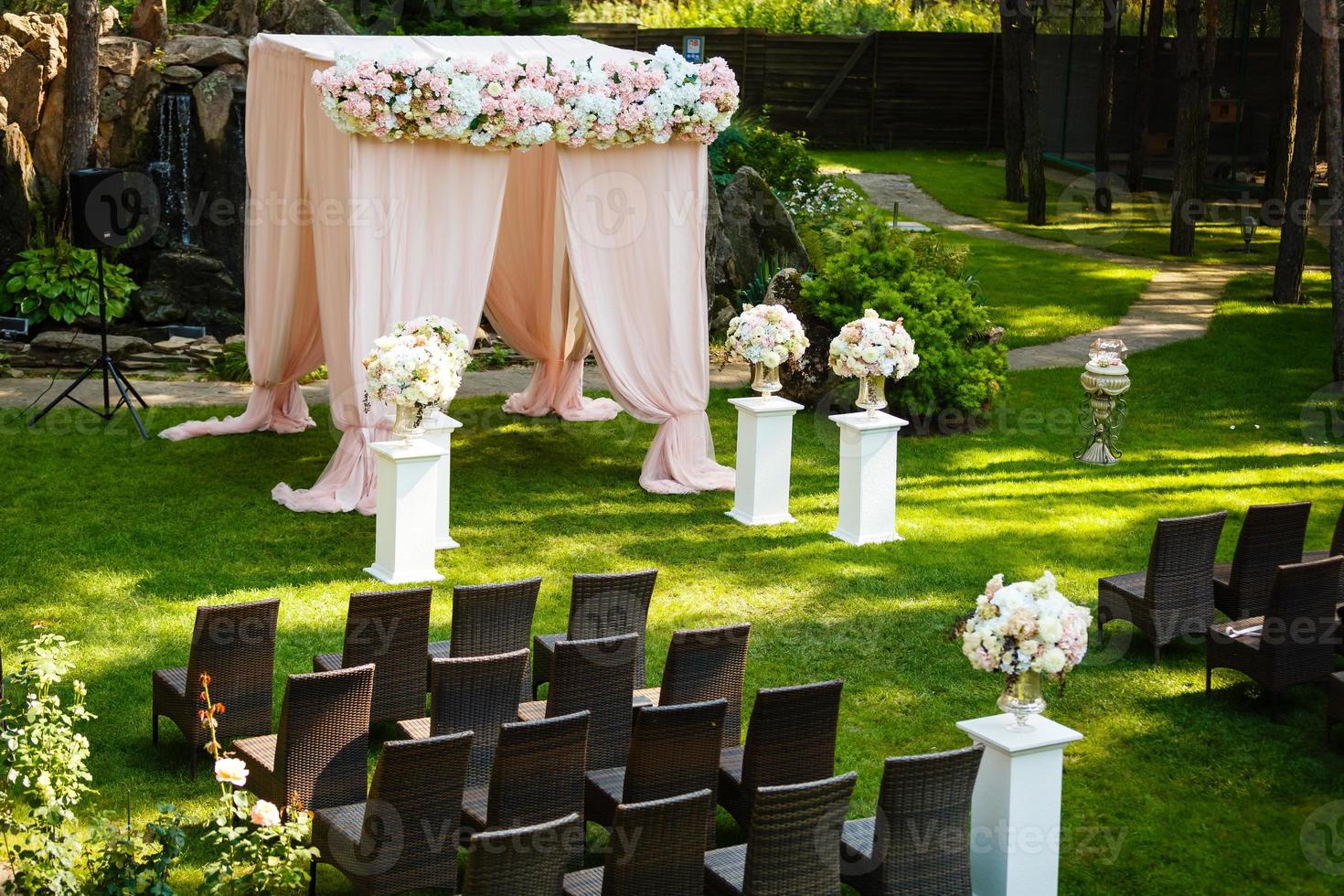 hermosos elementos de decoración de diseño de ceremonia de boda con arco, diseño floral, flores y sillas. foto