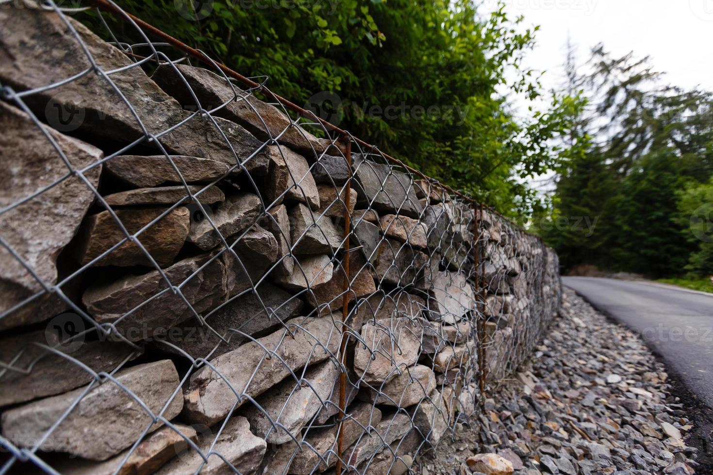 Slope and earth retention wall management with rocks and wire mesh cage system in tropical hilly terrain photo