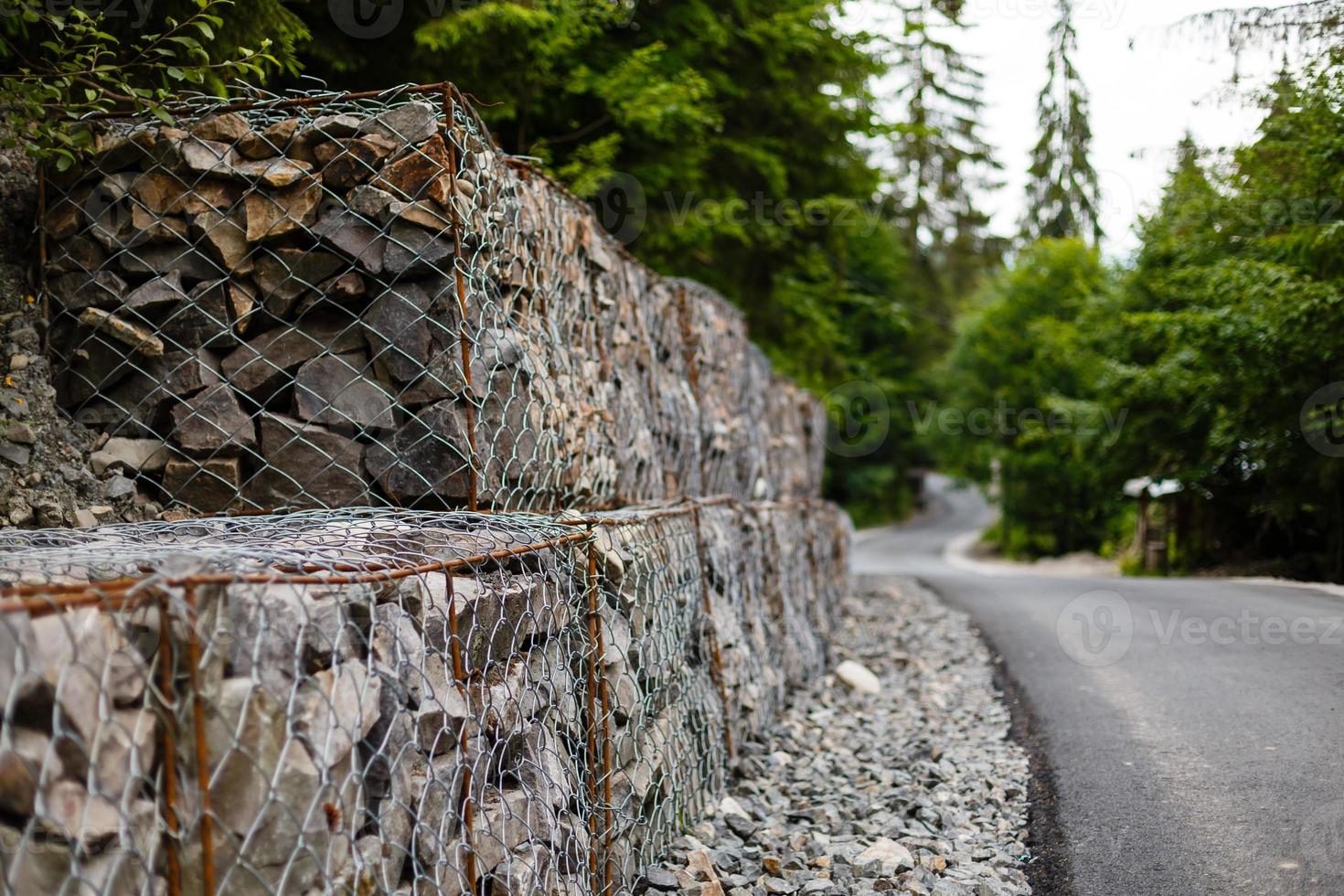 gestión de taludes y muros de contención de tierra con rocas y sistema de jaulas de malla de alambre en terreno montañoso tropical foto