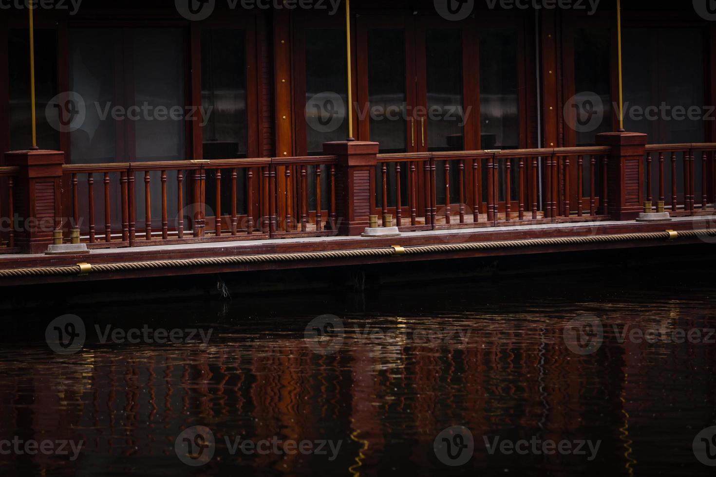 Port of old wooden yacht moored on Motlau river in Gdansk old town at dawn. In the background waterfront buildings reflecting on water. photo