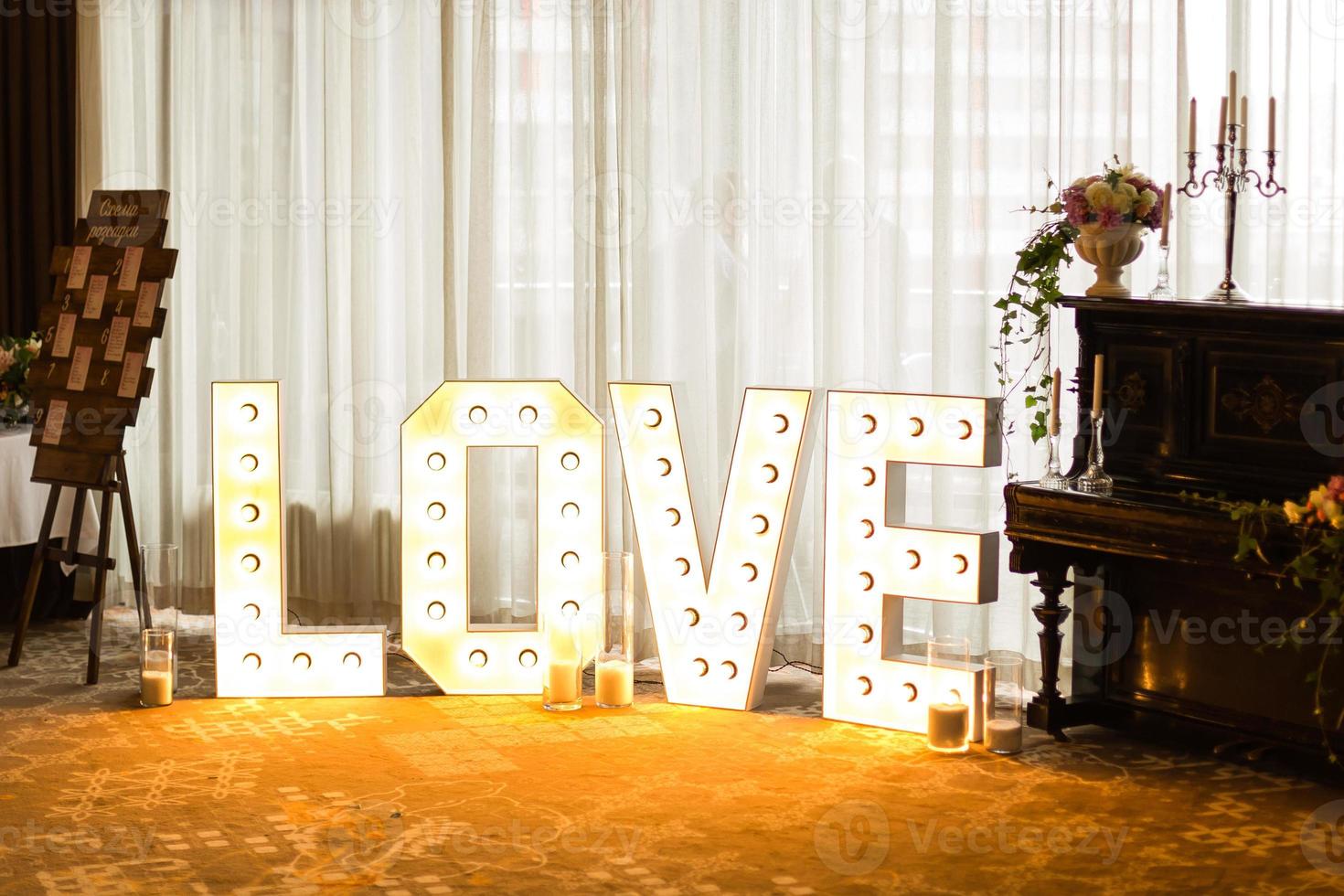 Inscription love from bulbs, Valentine day and christmas background. Blurred word Love for valentine day and merry christmas photo