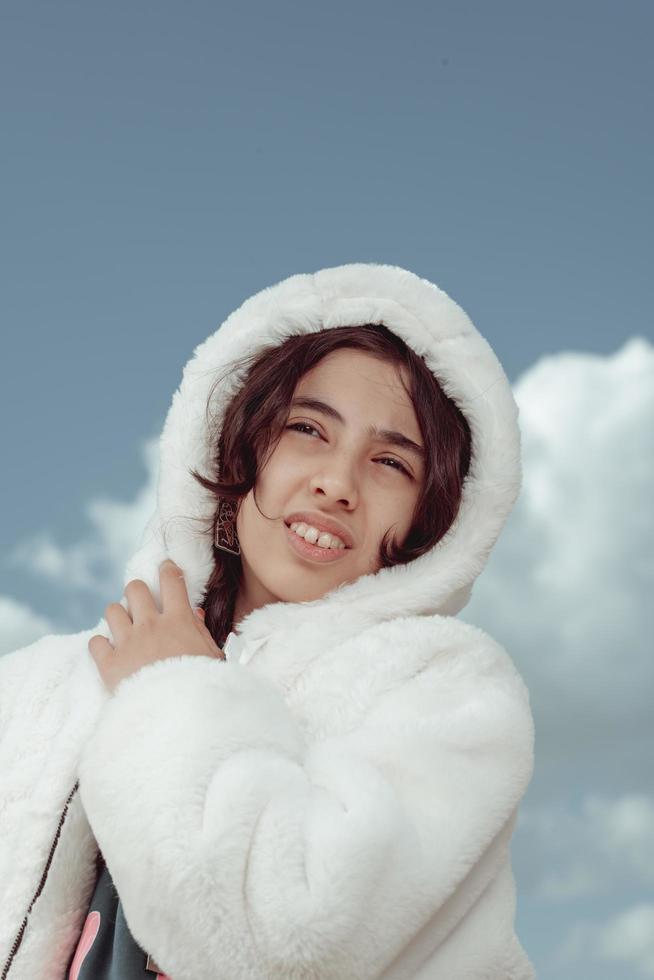 A beautiful girl from the Middle East, Egypt, wearing a white fur coat photo