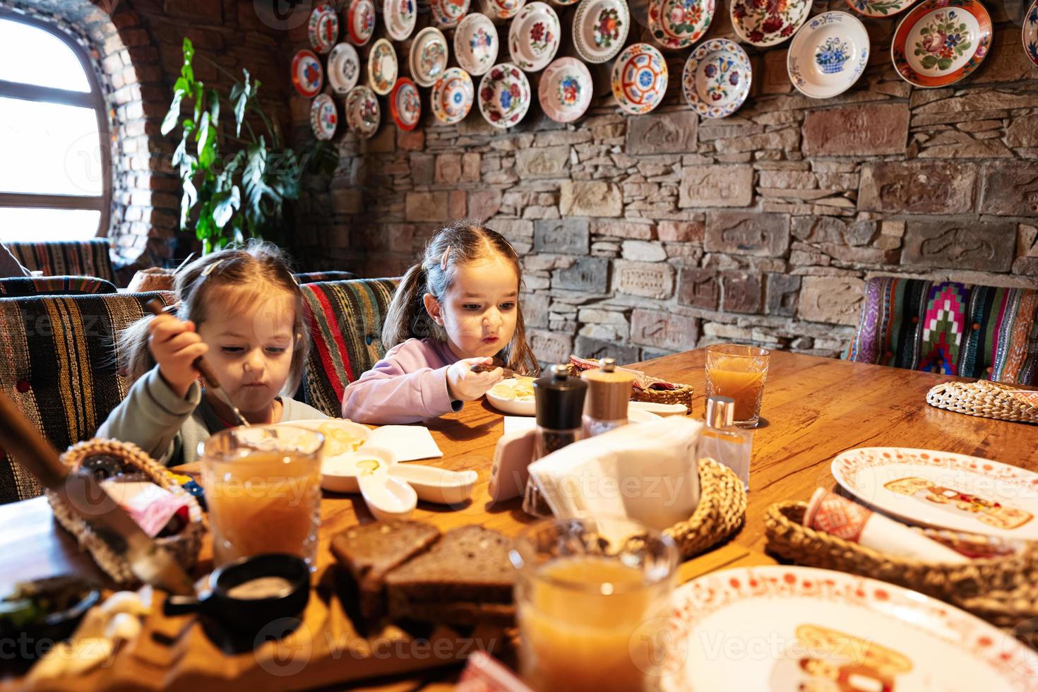 familia comiendo juntos en un auténtico restaurante ucraniano. las niñas comen albóndigas. foto