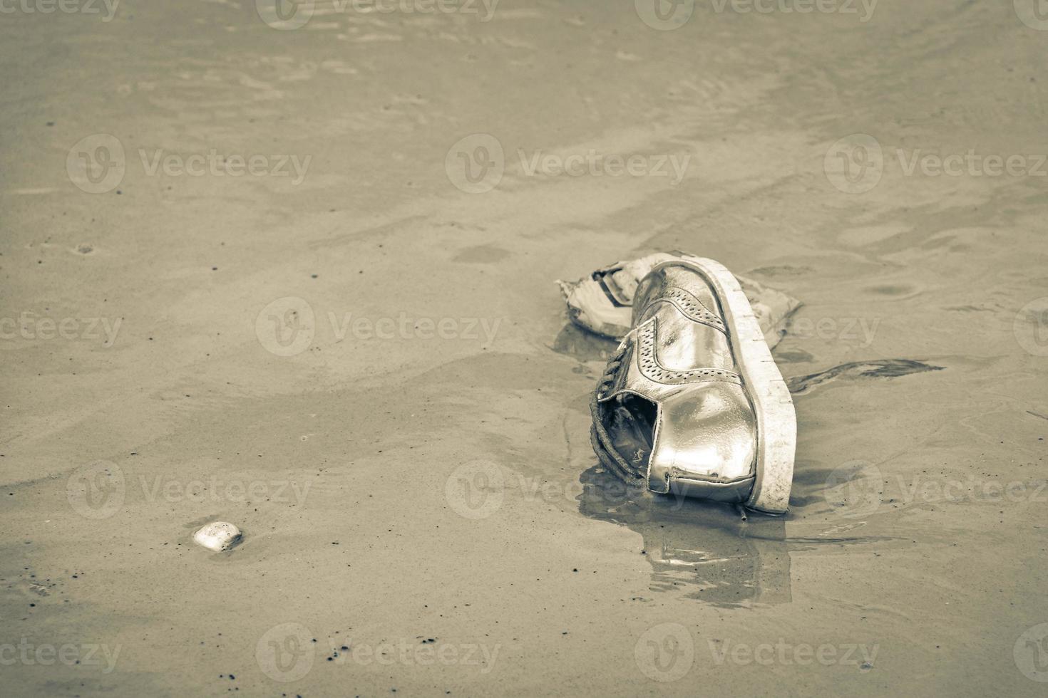 Golden shoe stranded washed up garbage pollution on beach Brazil. photo