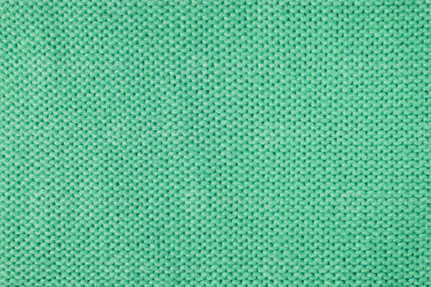 Bright green knitwear wool fabric texture background. Abstract textile backdrop photo
